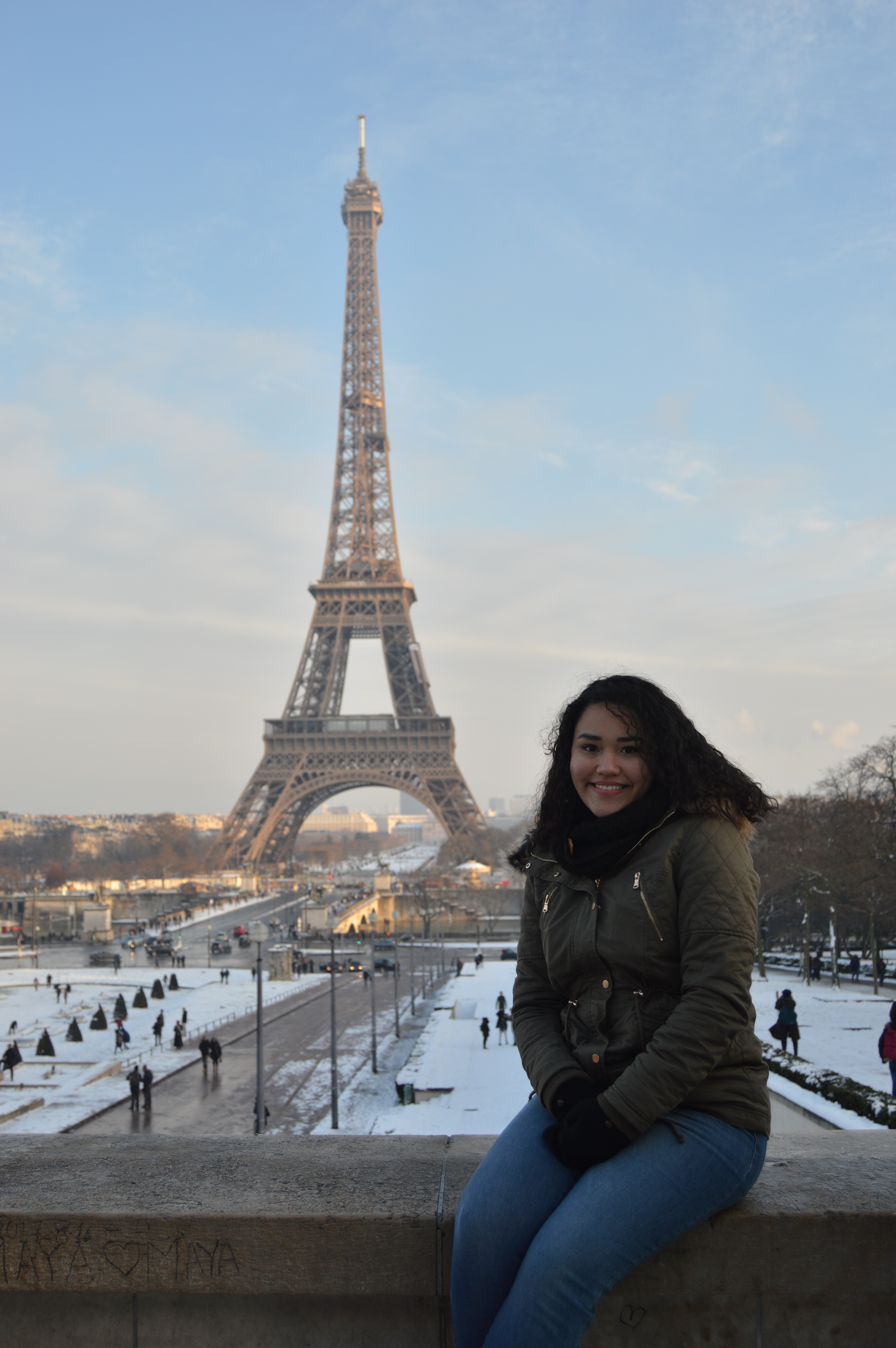 Student posing in front of the Eiffel Tower in Paris with snow