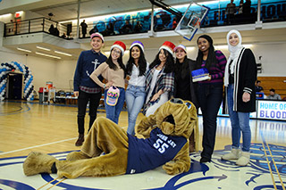 John Jay Bloodhound posing with students