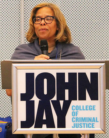 Karol Mason speaking behind a John Jay College podium