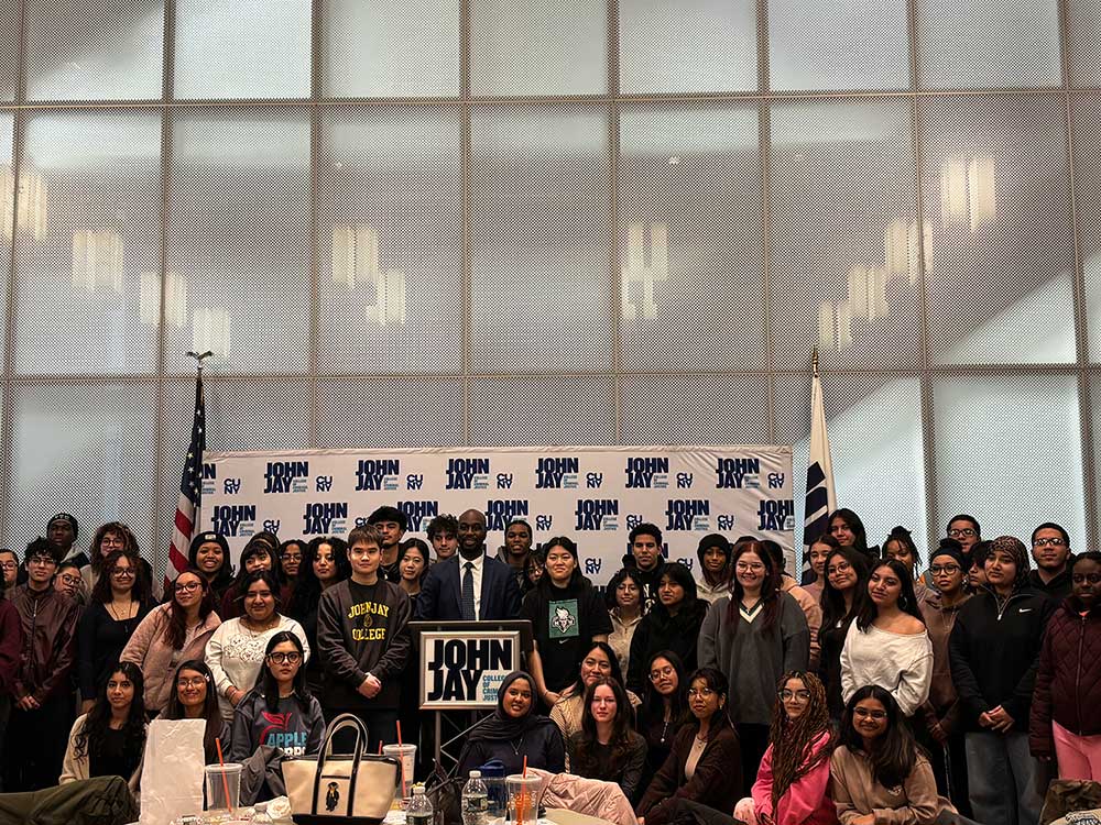 Donovan Borington poses with a large group of John Jay APPLE Corps Students