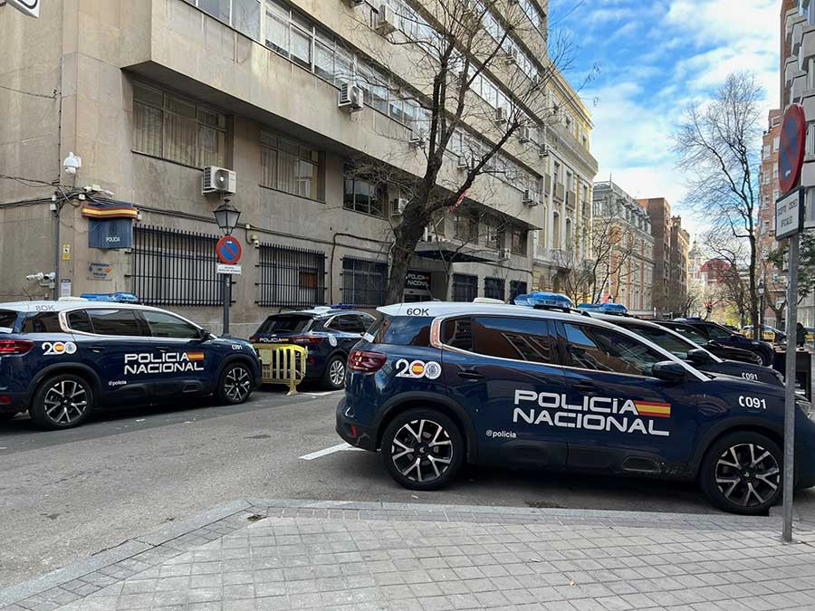 Dark blue Spanish National Police cars parked along a city street