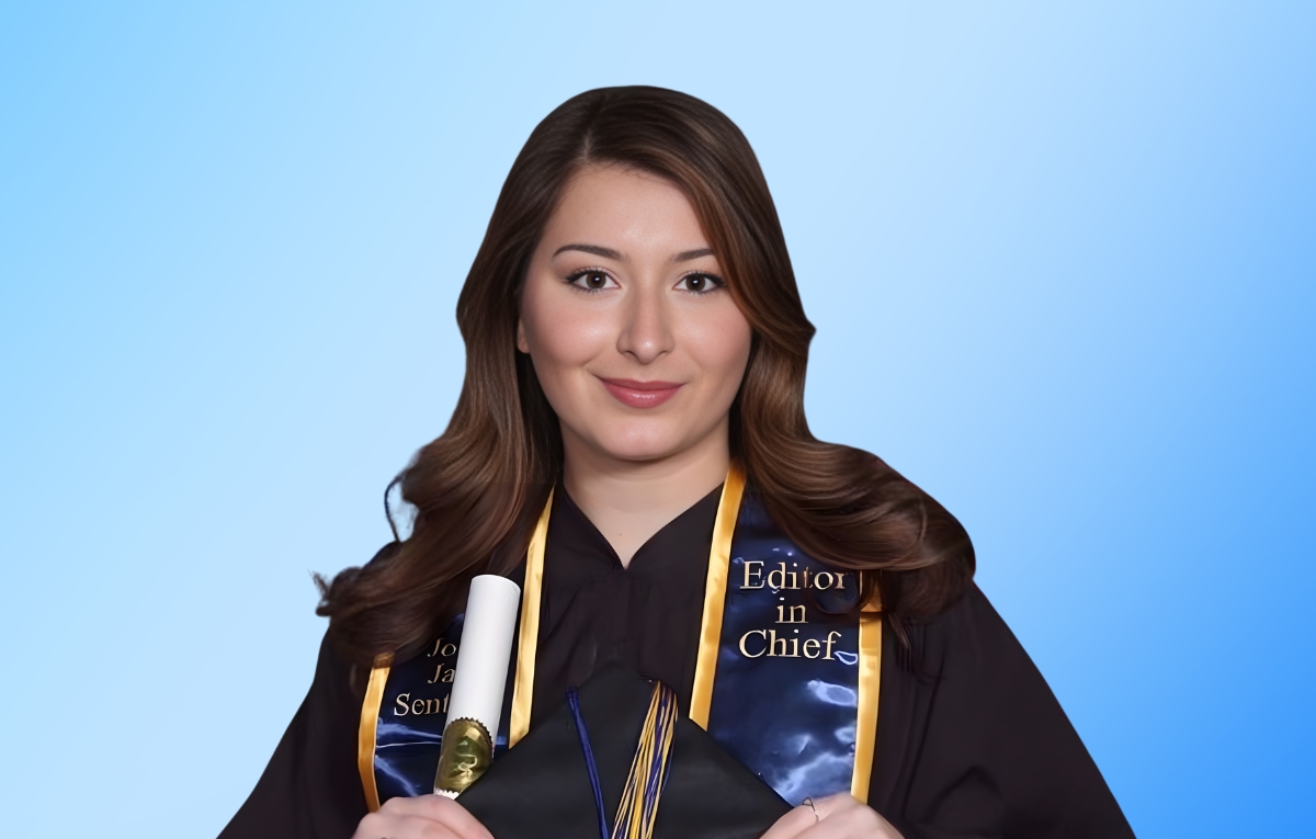 Alexandra Cortese, sits facing the camera. She is wearing her graduation gown and John Jay Sentinel stole