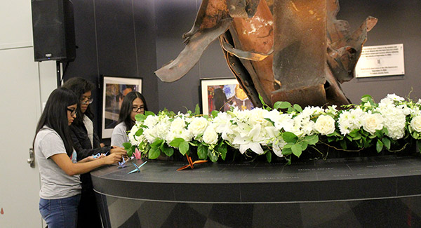Students placing paper cranes on the memorial site
