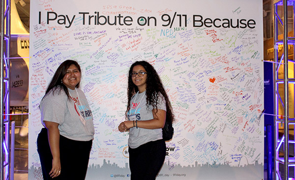 APPLE Corps’ Doménica Ramírez-Pérez ’18 and Rosalma Pineda ’21 sign the 9/11 Tribute Wall