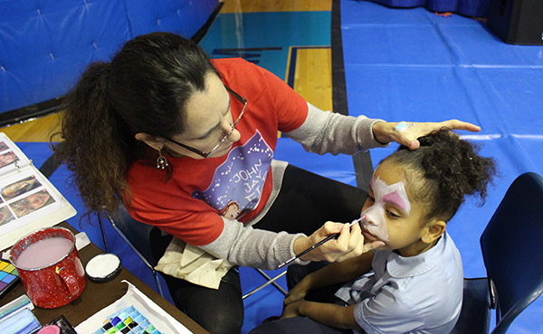 Laura DeVries, Senior Designer, meticulously paints a child’s face. 