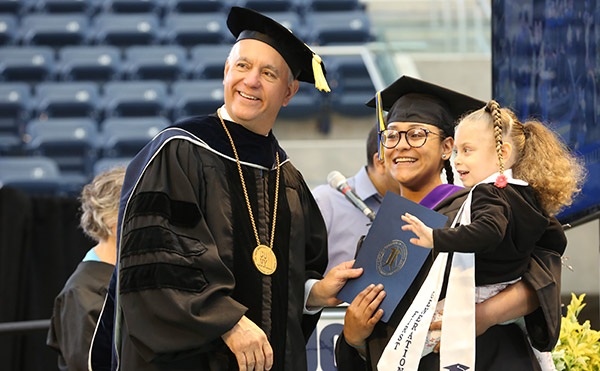 CUNY Chancellor, Félix V. Matos Rodríguez poses with a John Jay graduate