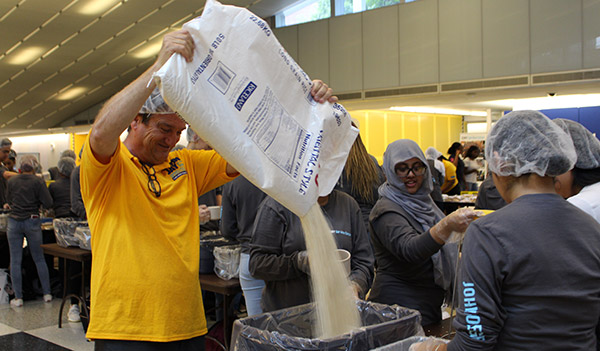 Director of COSL, Declan Walsh refills the rice supply