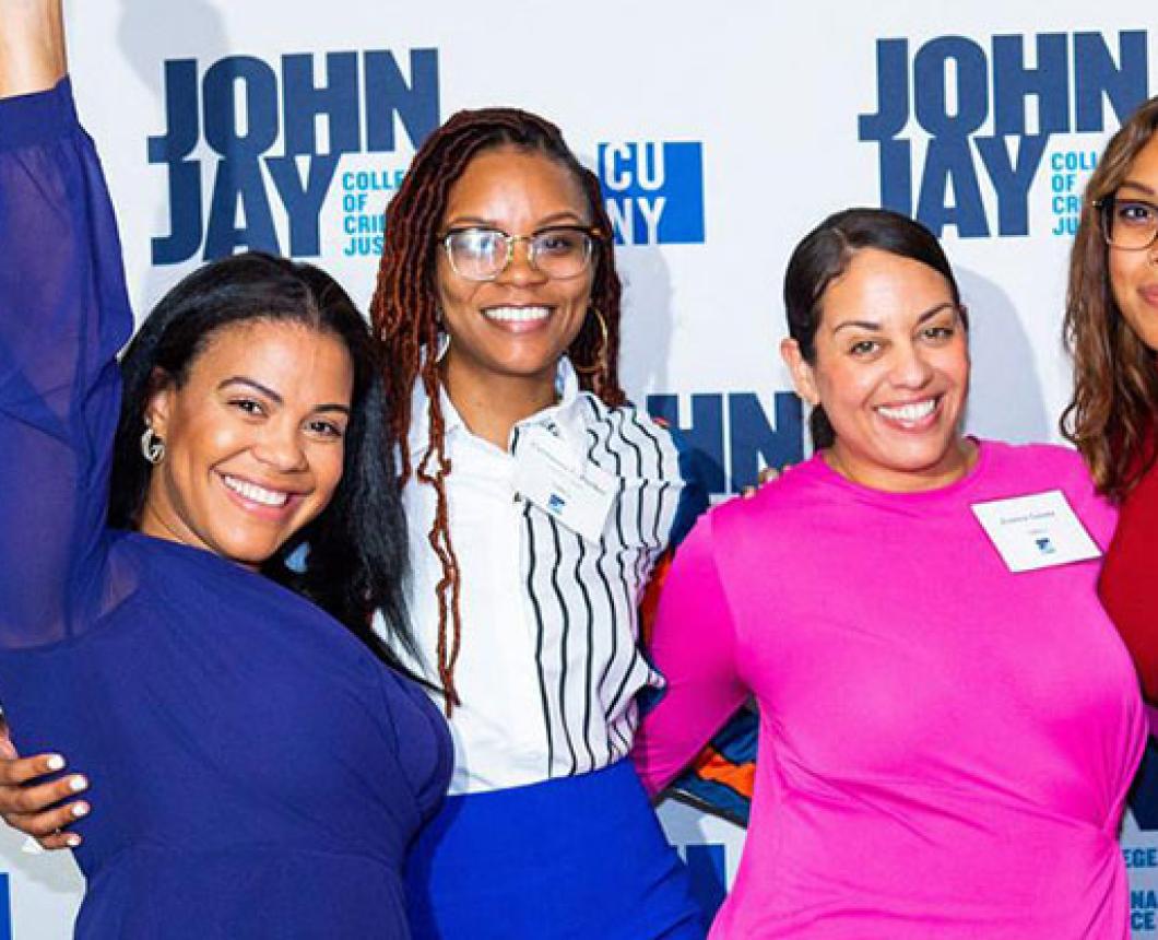 Four women posing at John Jay College event