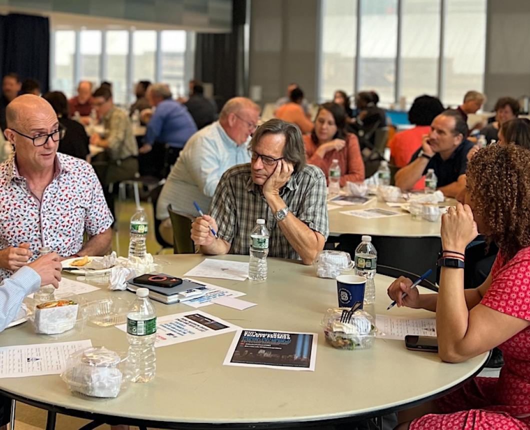 group photo of John Jay faculty eating lunch at a round table
