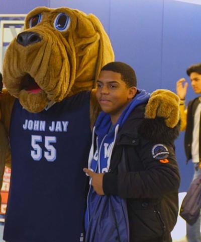 John Jay College mascot Bloodhound posing with students