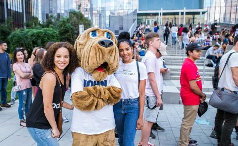 Students posing with John Jay's mascot the Bloodhound on Jaywalk
